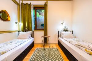 2 camas en una habitación con ventana en Blacksmith's House - Old Town, en Plovdiv