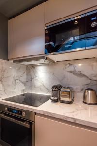 a kitchen with white marble counter tops and a stove at Séjour au Taj proche Tour-Eiffel in Paris