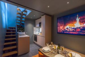 a kitchen with a tv on the wall and a staircase at Séjour au Taj proche Tour-Eiffel in Paris +22 photos