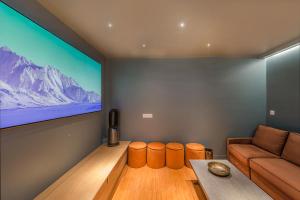 a living room with a couch and a television at Séjour au Taj proche Tour-Eiffel in Paris