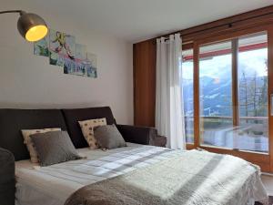 Un dormitorio con una cama y una ventana grande. en Apartment Beausoleil 4 by Interhome, en Verbier