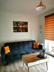 a living room with a blue couch and a coffee table at Apartament nad Jeziorem w Olecku in Olecko