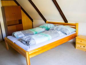 a wooden bed with pillows on it in a room at Holiday Home Kemp Stříbrný rybník-8 by Interhome in Hradec Králové