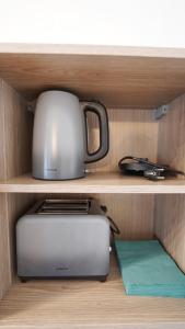 einen Toaster und einen Toaster auf einem Regal in der Unterkunft CozyNite Premium Apartment Hernals 1 in Wien