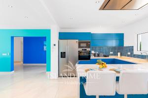 een blauwe en witte keuken met een tafel en stoelen bij Private Villa in Golf del Sur in San Miguel de Abona
