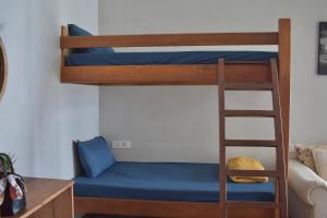 a bunk bed with blue sheets and a ladder at BeachBums Lodge in Westbrook