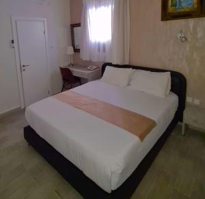 a bedroom with a large white bed and a window at Hotel Alma - Near The Sea in Netanya