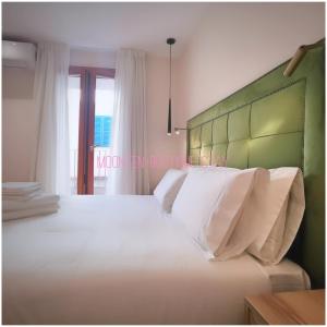 - une chambre avec un grand lit blanc et une tête de lit verte dans l'établissement MOONTEN Boutique Stay, à Sóller