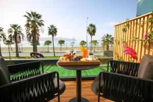 un tavolo con un piatto di cibo su un balcone di Charm Hotel a Vlorë