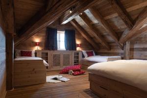 a bedroom with two beds and a wooden ceiling at Bayernhütte am Brauneck in Lenggries