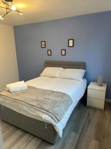 Stylish Apartment At Carlton Grove في لندن: سرير كبير في غرفة نوم بجدران زرقاء