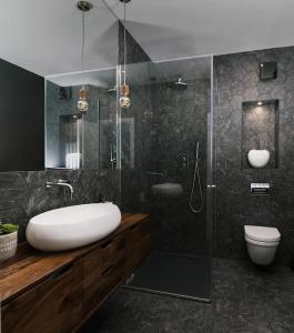 uma casa de banho com um lavatório, um chuveiro e um WC. em The Kensington Penthouse Suite em Londres