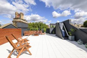 um pátio com cadeiras de madeira no telhado em The Kensington Penthouse Suite em Londres