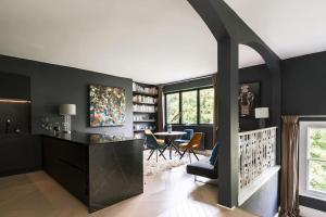 uma sala de estar com paredes pretas e uma mesa e cadeiras em The Kensington Penthouse Suite em Londres
