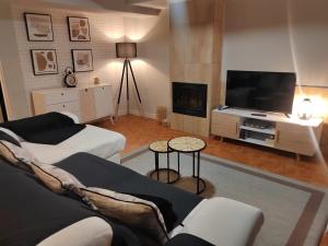 uma sala de estar com um sofá e uma televisão de ecrã plano em Apartamentos Playa de Camariñas em Camarinhas