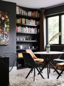 uma sala de estar com mesa e cadeiras e uma estante de livros em The Kensington Penthouse Suite em Londres