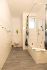 ein weißes Badezimmer mit einer Badewanne und einem Waschbecken in der Unterkunft Art City Studio Kassel 2 in Kassel