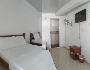 Habitación de hotel con 2 camas y TV en Hotel Zarina en Villavicencio