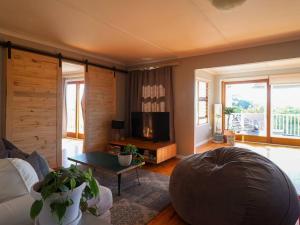 uma sala de estar com um sofá e uma televisão em Lush Spacious Family Home between Beach & Town em Knysna