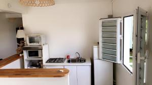 a small kitchen with a stove and a microwave at Appartement Topaze in La Trinité