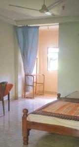 a bedroom with a bed and two chairs and a window at Kandalama Hostel in Dambulla