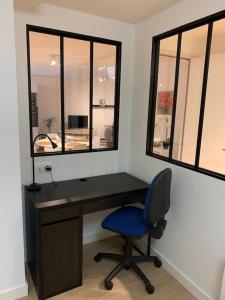 a desk with a blue chair and a mirror at Jaurès - Centre ville - T1 bis au calme in Brest