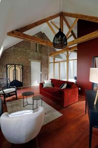 sala de estar con sofá rojo y pared de ladrillo en Le Domaine Saint Ange en Friville-Escarbotin