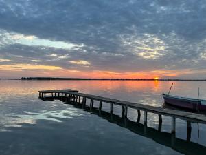 - un quai avec un bateau sur l'eau au coucher du soleil dans l'établissement Vila Horizont, à Baks-Rrjoll