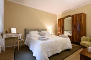 シエナにあるRomantico appartamento a Sienaのベッドルーム(鏡付きの大きな白いベッド1台付)