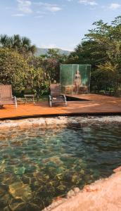 a pool of water with two chairs and a screen at Pousada Varanda da Serra in Cavalcante