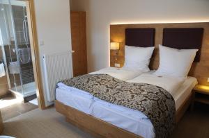 a bedroom with a large bed with white sheets and pillows at Hotel ten Hoopen Restaurant Deele in Warburg