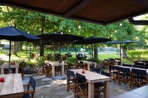 a patio with tables and chairs with umbrellas at Camping Pittoresque in Saint-Parthem