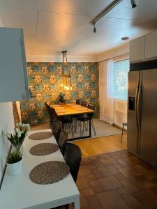 a kitchen and dining room with a table and a refrigerator at Villa Närhi 230 m2 upea talo rauhallisella alueella in Seinäjoki