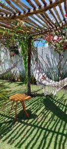 a hammock and a bench under a pergola at Arataba Hotel Boutique e Bistrô - 150 mts do mar in Pôrto de Pedras