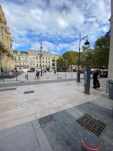 een stadsplein met wandelende mensen en een gebouw bij Appartement Paul riquet avec place de parking in Béziers