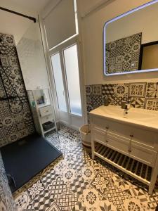 een badkamer met een wastafel, een toilet en een spiegel bij Appartement Paul riquet avec place de parking in Béziers
