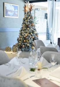 a christmas tree in front of a table in a restaurant at Magnolia Place in Tivat