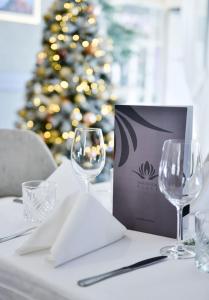 uma mesa com dois copos de vinho e uma árvore de Natal em Magnolia Place em Tivat