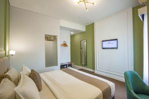 A bed or beds in a room at Hotel FortunaGrande Malioboro Yogyakarta