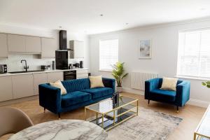 斯卡伯勒The Salisbury - Luxury Apartments by Stay In Scarborough的一间带2张蓝色沙发的客厅和一间厨房