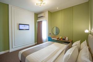 A bed or beds in a room at Hotel FortunaGrande Malioboro Yogyakarta
