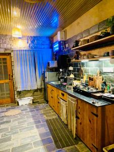een grote keuken met houten kasten en een aanrecht bij Hobbit House Bir in Bir