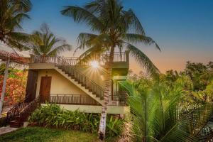 une maison avec des escaliers et un palmier dans l'établissement Ganesha Kampot Resort, à Kampot