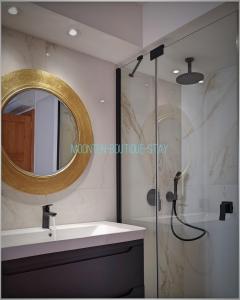 a bathroom with a sink and a shower with a mirror at MOONTEN Boutique Stay in Sóller