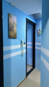 a blue room with a phone and a blue wall at Deluxe Loft Rooms near Burjuman Metro Station , Bur Dubai in Dubai