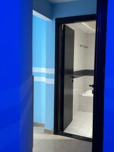 uma casa de banho com uma porta de vidro que leva a um chuveiro em Deluxe Loft Rooms near Burjuman Metro Station , Bur Dubai em Dubai
