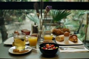 uma mesa coberta com pratos de comida e copos de sumo de laranja em Hotel Matelote em Antuérpia