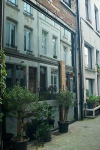 a store front with potted trees in front of a building at Hotel Matelote in Antwerp