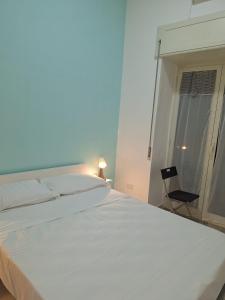 - une chambre avec un grand lit blanc et une chaise dans l'établissement Cisterna’s house, à Naples