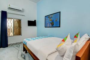 een slaapkamer met een bed en een raam bij OYO Nilay Guest House in Behāla